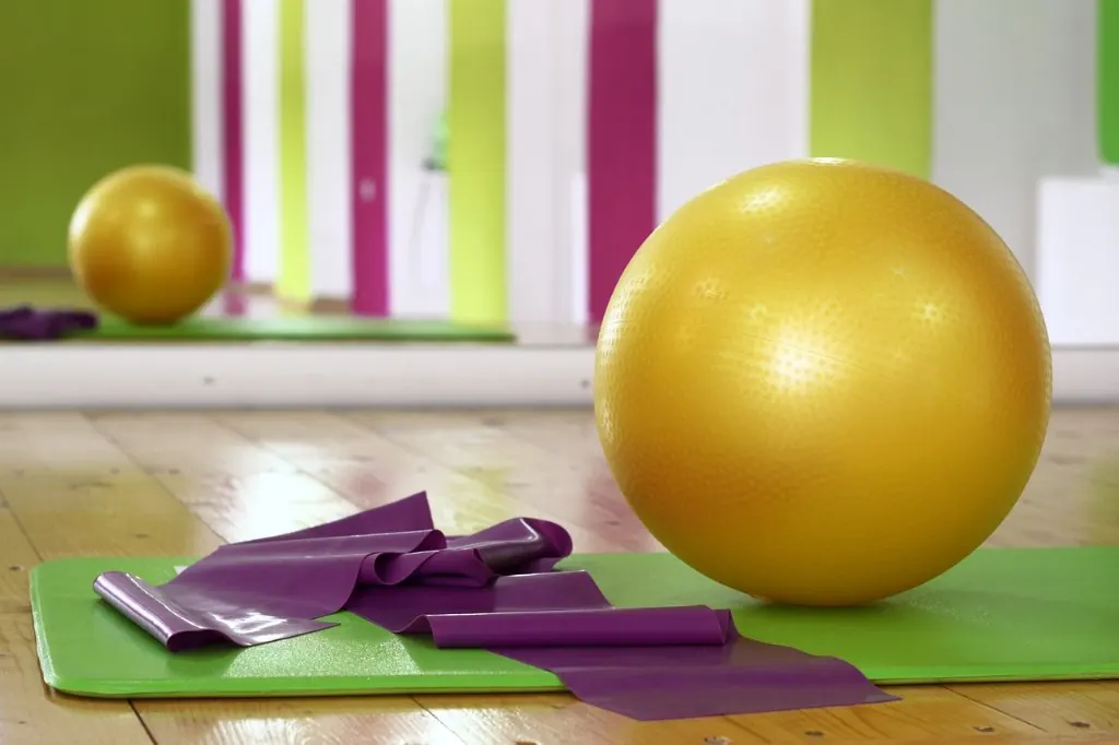 Pelota de pilates y banda elástica sobre una esterilla